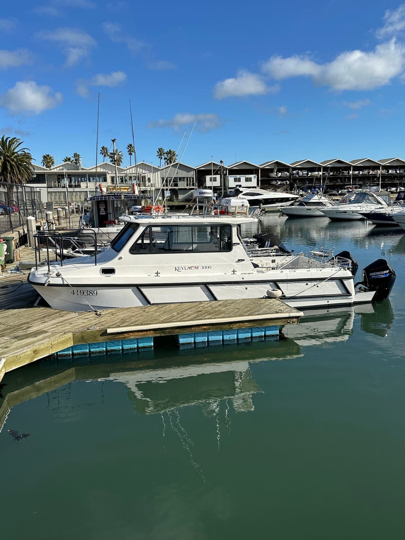 The charter boat at the marina with apartments and moored boats behind